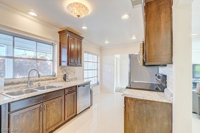 kitchen with appliances with stainless steel finishes, a healthy amount of sunlight, decorative backsplash, and sink