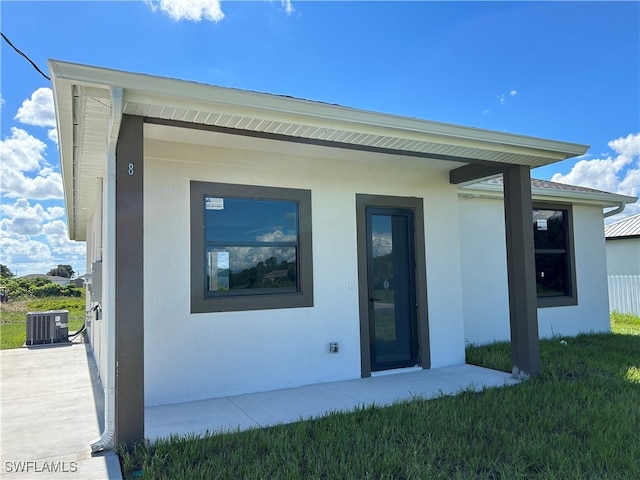 exterior space with cooling unit, a yard, and a patio