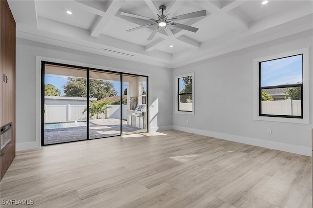 empty room with a wealth of natural light, light hardwood / wood-style flooring, and ceiling fan