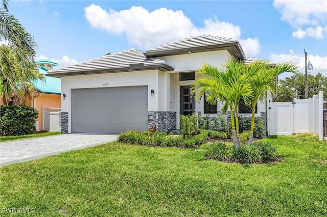 689 101st Ave N, Naples, FL 34108 - prairie-style house featuring stone siding, an attached garage, stucco siding, and decorative driveway