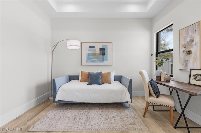 689 101st Ave N, Naples, FL 34108 - bedroom featuring light wood-style floors, a tray ceiling, and baseboards