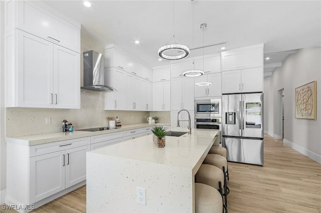 689 101st Ave N, Naples, FL 34108 - kitchen featuring stainless steel appliances, wall chimney exhaust hood, recessed lighting, a sink, and white cabinets