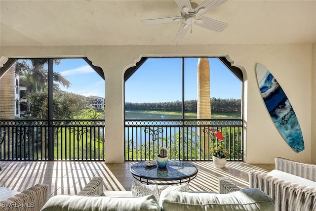 sunroom / solarium with ceiling fan, a healthy amount of sunlight, and a water view