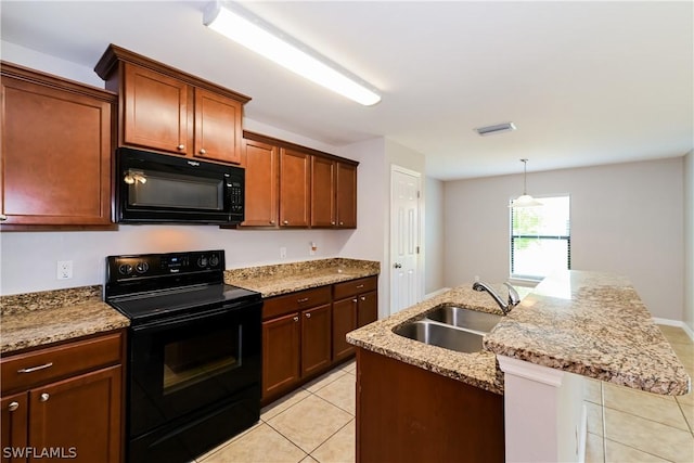 kitchen featuring black appliances, sink, light tile patterned floors, an island with sink, and light stone counters