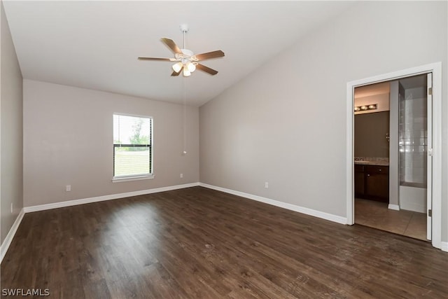 spare room featuring ceiling fan, dark wood-type flooring, and vaulted ceiling