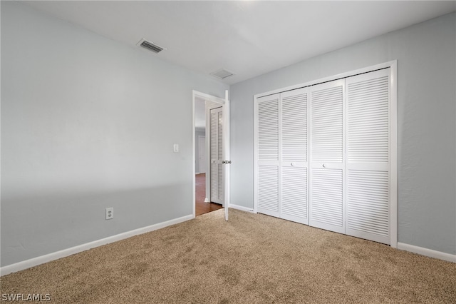 unfurnished bedroom featuring carpet and a closet