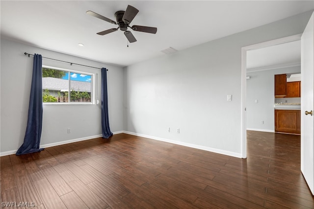 empty room with dark hardwood / wood-style flooring and ceiling fan