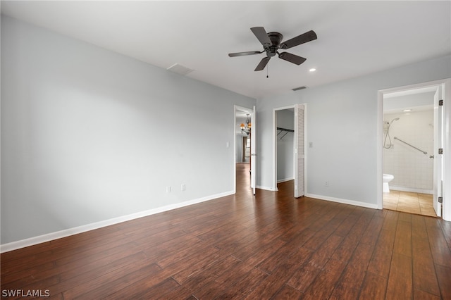 unfurnished bedroom with dark hardwood / wood-style flooring, ensuite bathroom, ceiling fan, a spacious closet, and a closet