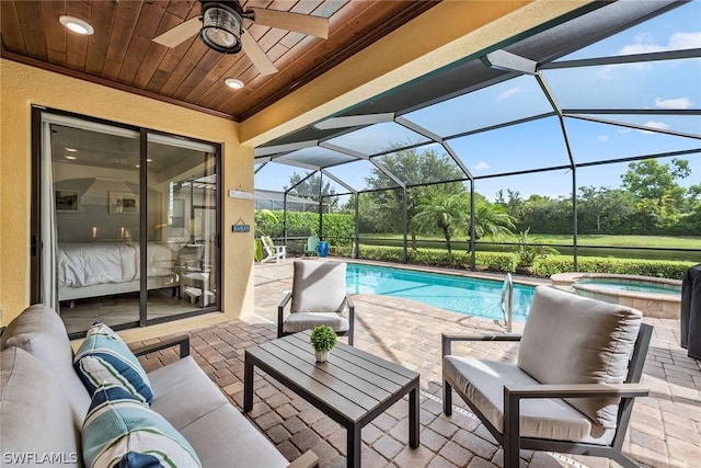 view of pool featuring an in ground hot tub, ceiling fan, a lanai, a patio, and outdoor lounge area