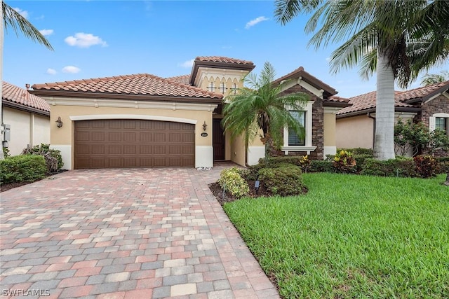 mediterranean / spanish house featuring a front yard and a garage