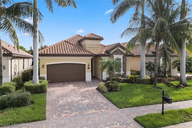 mediterranean / spanish-style home featuring a front lawn and a garage