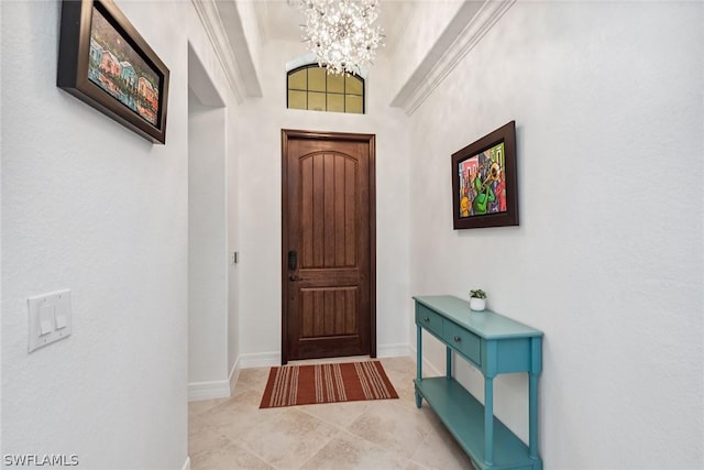 foyer with a towering ceiling, crown molding, light tile patterned floors, and a notable chandelier