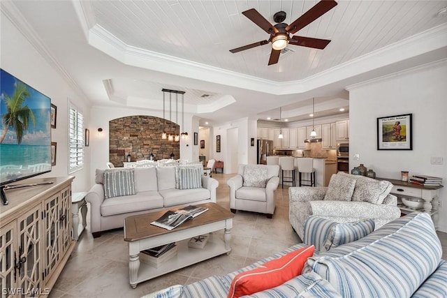 living room featuring a raised ceiling, ceiling fan, crown molding, and light tile patterned floors