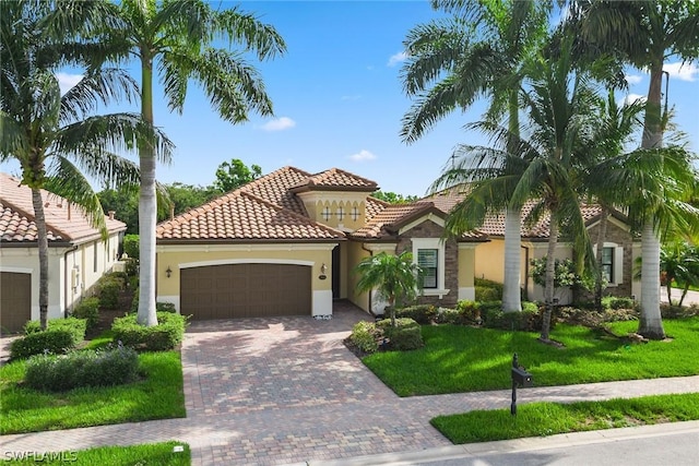 mediterranean / spanish-style house featuring a front yard and a garage