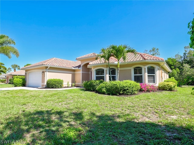 mediterranean / spanish-style house with a front yard and a garage