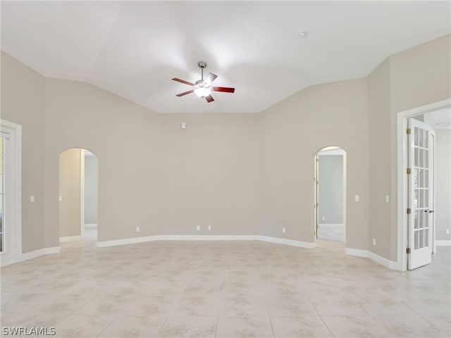 spare room with ceiling fan, light tile patterned flooring, and vaulted ceiling