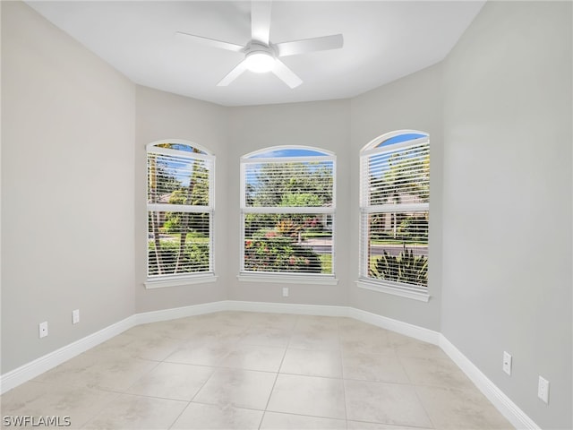 tiled spare room with ceiling fan and a healthy amount of sunlight