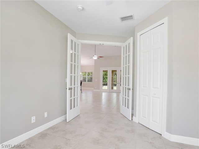 corridor with french doors and light tile patterned flooring