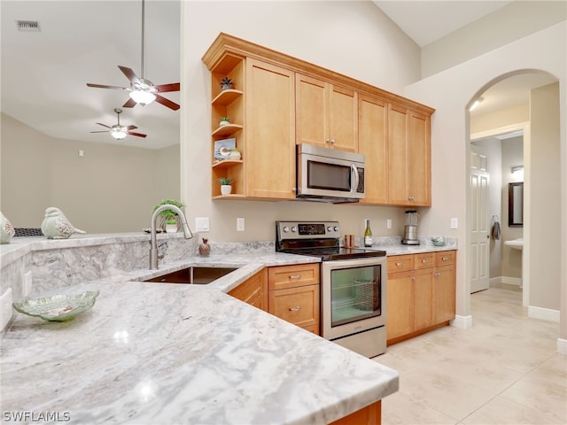 kitchen with light brown cabinetry, ceiling fan, sink, and appliances with stainless steel finishes