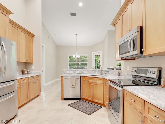 kitchen with sink, a notable chandelier, kitchen peninsula, decorative light fixtures, and appliances with stainless steel finishes