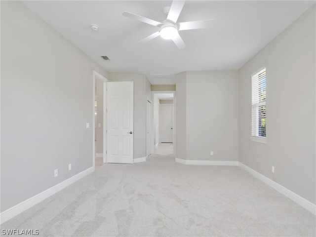 carpeted spare room featuring ceiling fan