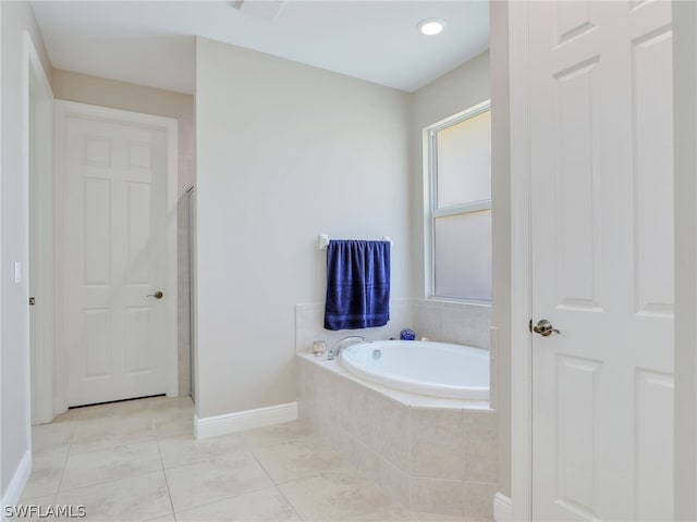 bathroom featuring tile patterned flooring and a relaxing tiled tub