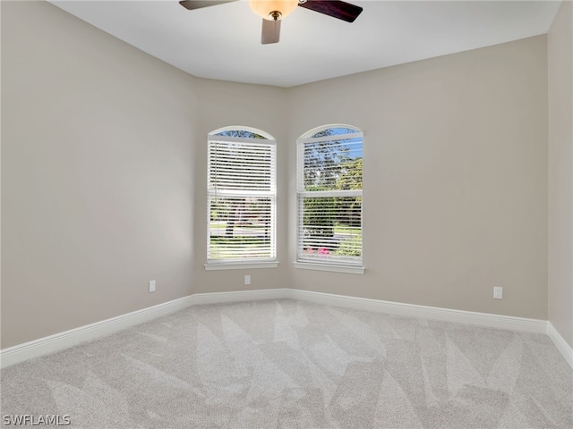 carpeted spare room with ceiling fan and a healthy amount of sunlight