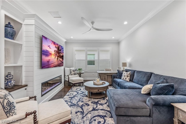 living area with dark wood-style flooring, a fireplace, visible vents, ornamental molding, and a ceiling fan