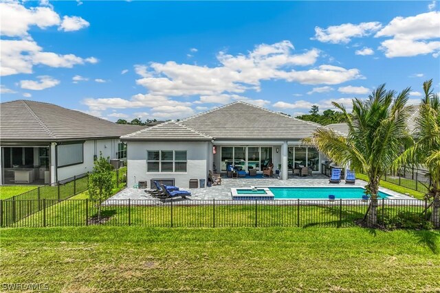 rear view of house featuring a fenced in pool, a patio, and a lawn