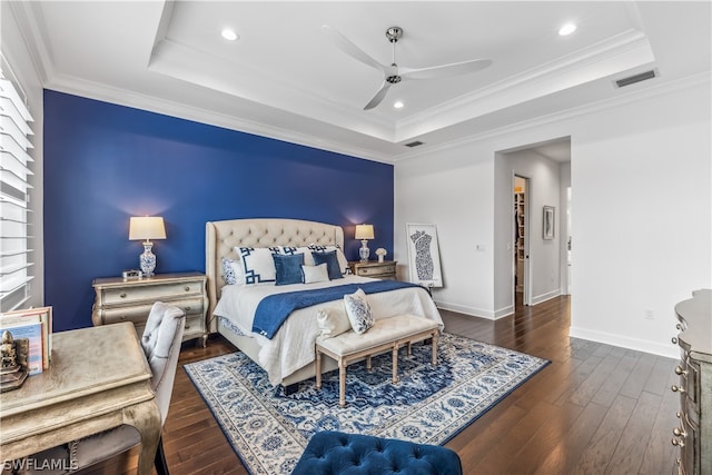 bedroom with dark wood-type flooring, a raised ceiling, ceiling fan, and crown molding