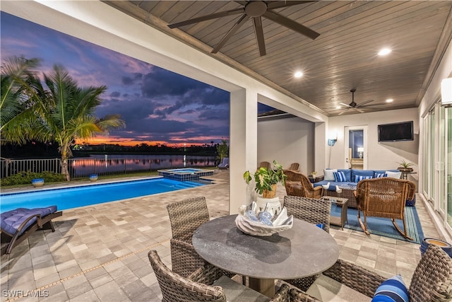 view of swimming pool featuring an outdoor living space, a water view, a patio, and ceiling fan