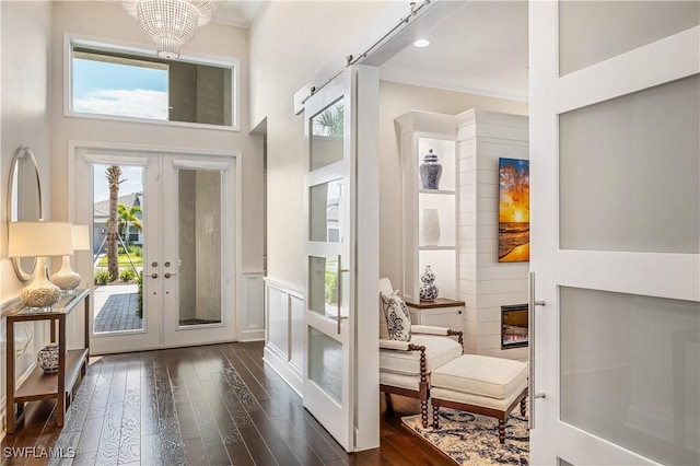 doorway to outside featuring a towering ceiling, dark wood-type flooring, crown molding, french doors, and recessed lighting