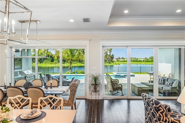 sunroom featuring a water view, a notable chandelier, and a healthy amount of sunlight