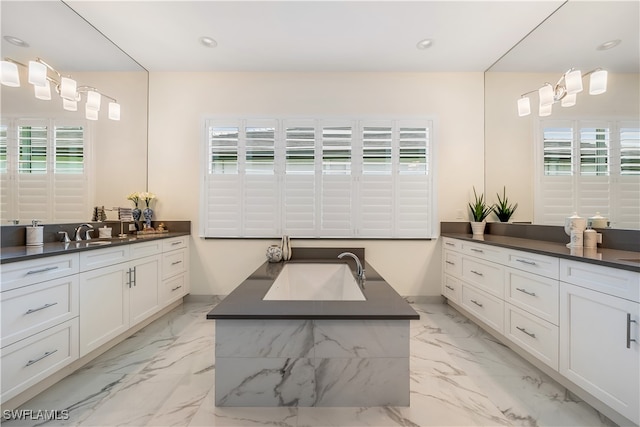 bathroom with a bathing tub, plenty of natural light, and vanity