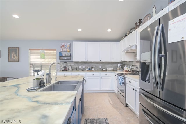 kitchen with decorative backsplash, white cabinetry, light tile patterned flooring, sink, and stainless steel appliances