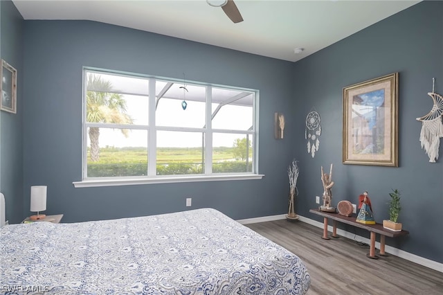 bedroom featuring multiple windows, hardwood / wood-style floors, lofted ceiling, and ceiling fan