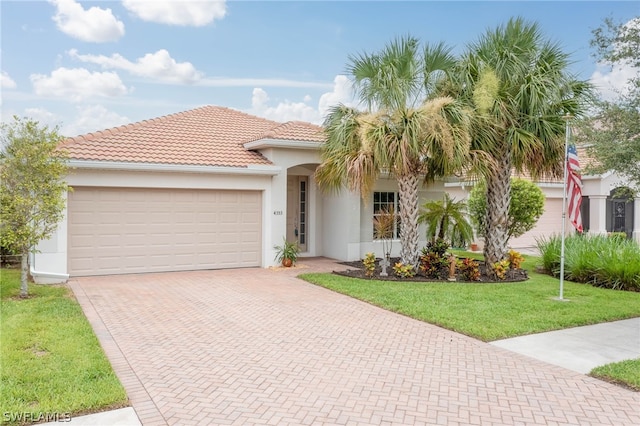 mediterranean / spanish home with a front yard and a garage