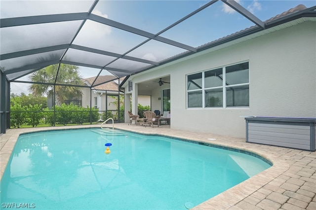 view of swimming pool featuring a patio area, ceiling fan, and glass enclosure