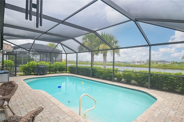 view of swimming pool featuring a patio, a lanai, and a water view