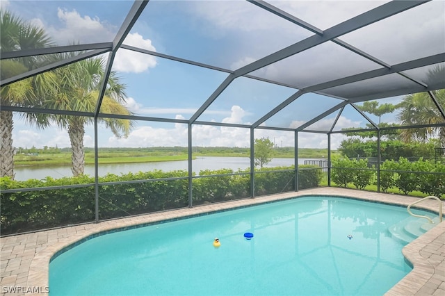 view of swimming pool with a water view, a patio area, and glass enclosure