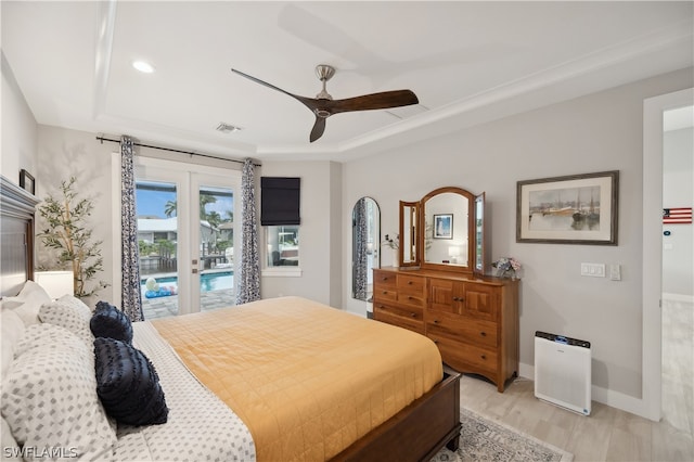 bedroom featuring ceiling fan, french doors, a raised ceiling, access to exterior, and hardwood / wood-style flooring