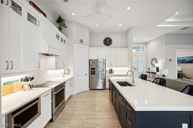 1641 Orleans Ct, Marco Island, FL 34145 - kitchen featuring a sink, appliances with stainless steel finishes, light wood-style flooring, light countertops, and an island with sink
