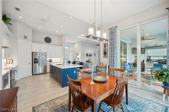 dining room featuring light hardwood / wood-style floors, sink, and ceiling fan