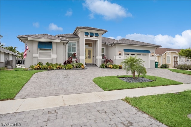 prairie-style house with a garage and a front lawn