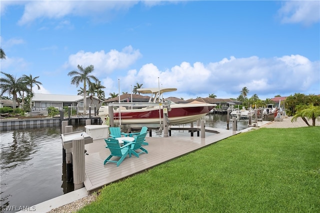 dock area with a lawn and a water view