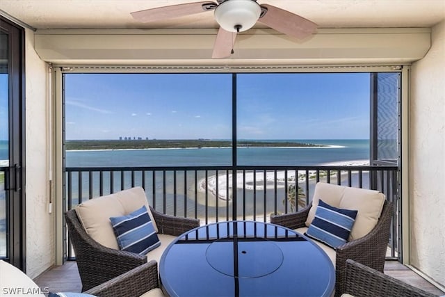 sunroom / solarium with a water view, a healthy amount of sunlight, and ceiling fan