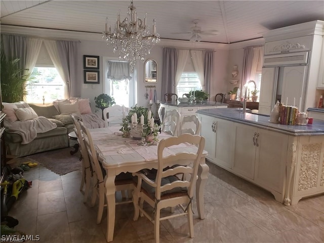 dining area with sink, a wealth of natural light, light tile flooring, and ceiling fan with notable chandelier