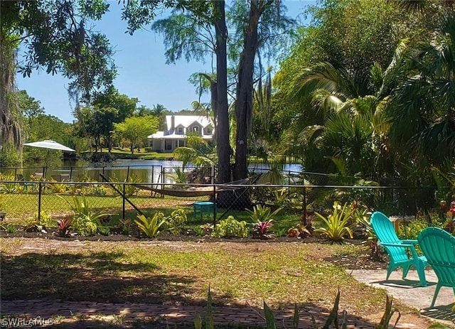 view of community with a water view and fence