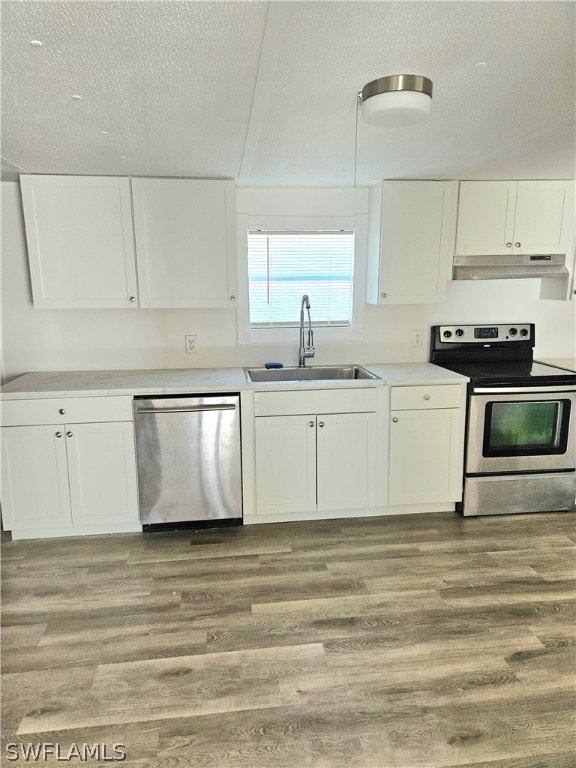 kitchen featuring wood-type flooring, a textured ceiling, sink, white cabinetry, and appliances with stainless steel finishes