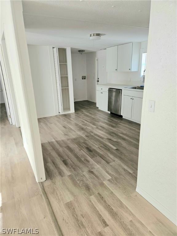 3200 Barrett Ave, Naples, FL 34112 - kitchen with white cabinetry, light wood-type flooring, dishwasher, and a sink
